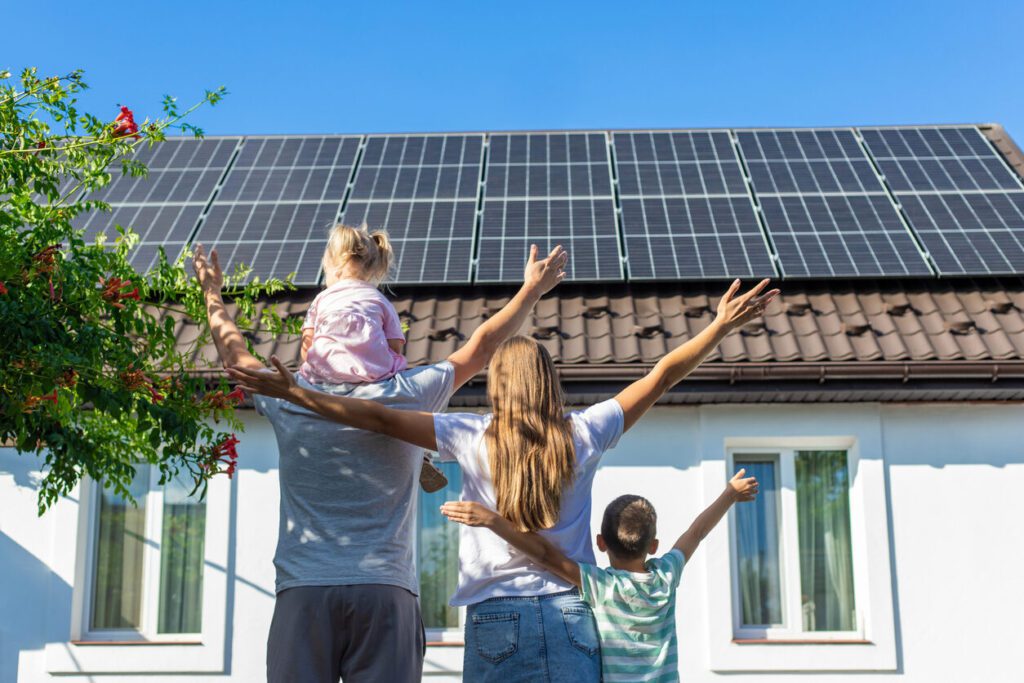 happy family on the background of a house with solar panels on the roof. Selective focus